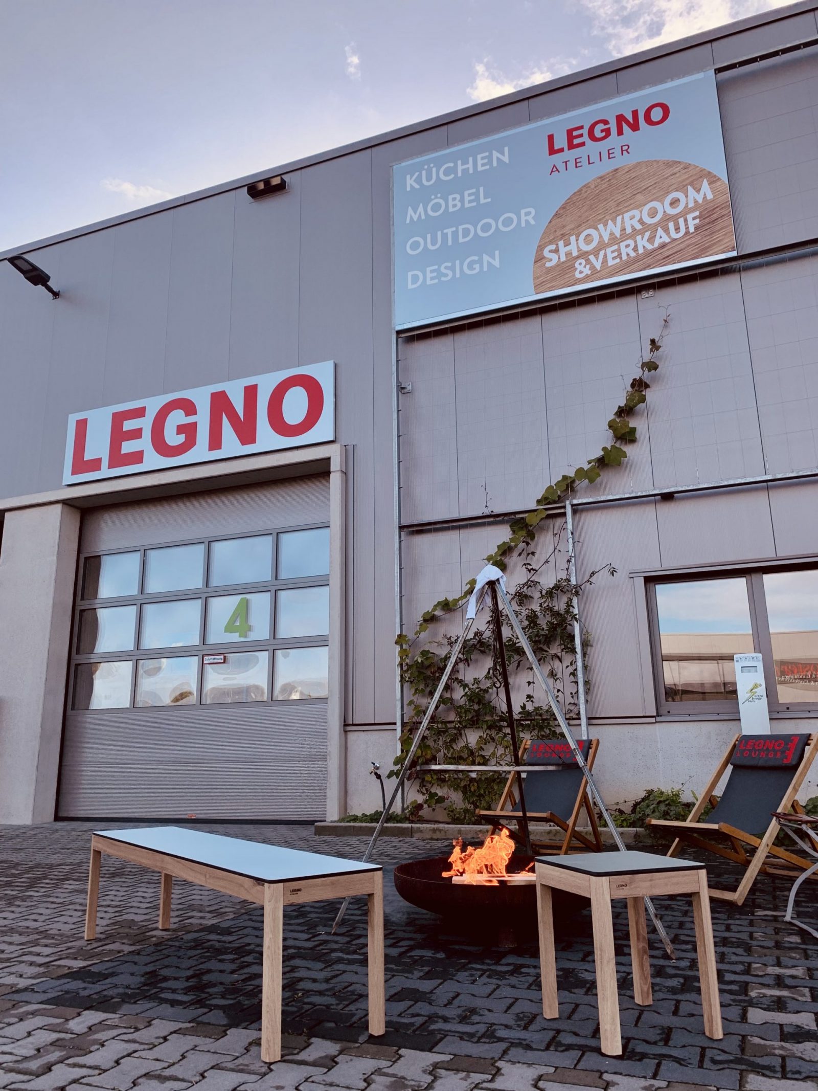 Außenansicht vom Legno Showroom in Krefeld mit Outdoor Möbeln aus Holz im Vordergrund aus der GRÄS Kollektion der Marke Legno Atelier aus Krefeld.